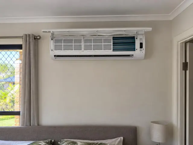 Clean split system indoor unit with open front panel and visible filters on a lounge room wall in Labrador